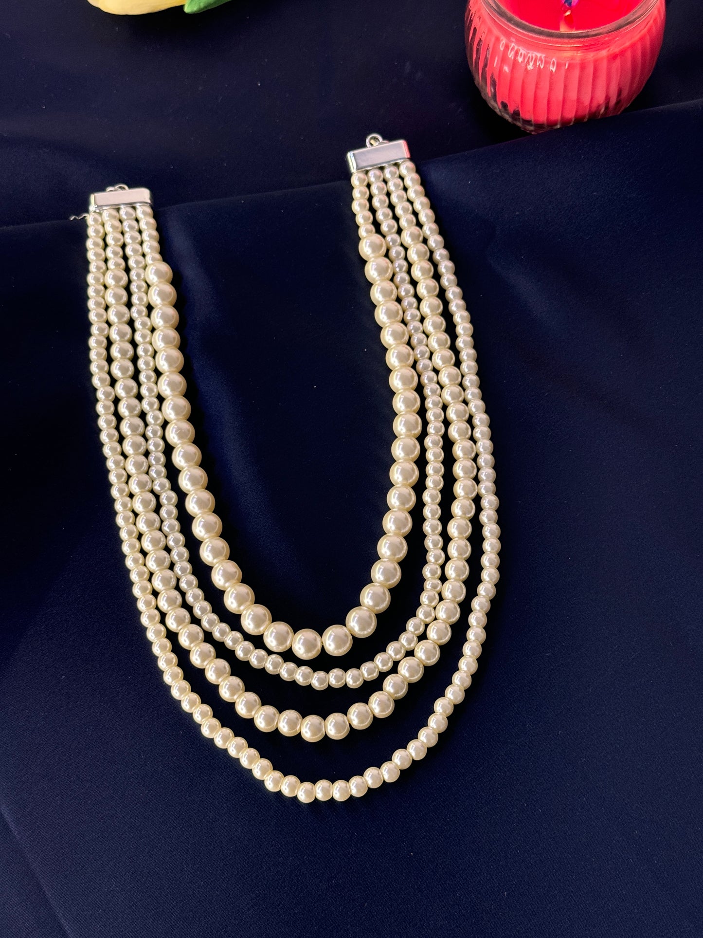 Pearl necklace on a dark blue fabric background
