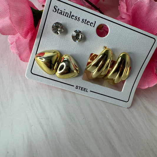 Three sets of anti-tarnish studs in gold color, presented on a card, with a pink floral background.