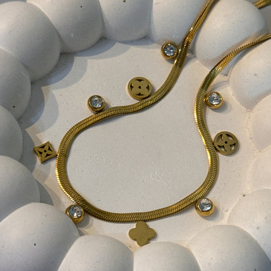 Gold bracelet with decorative elements on a white spherical surface