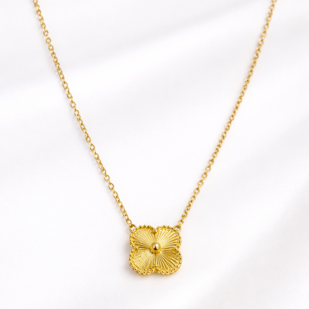 Gold necklace with a floral pendant on a white background