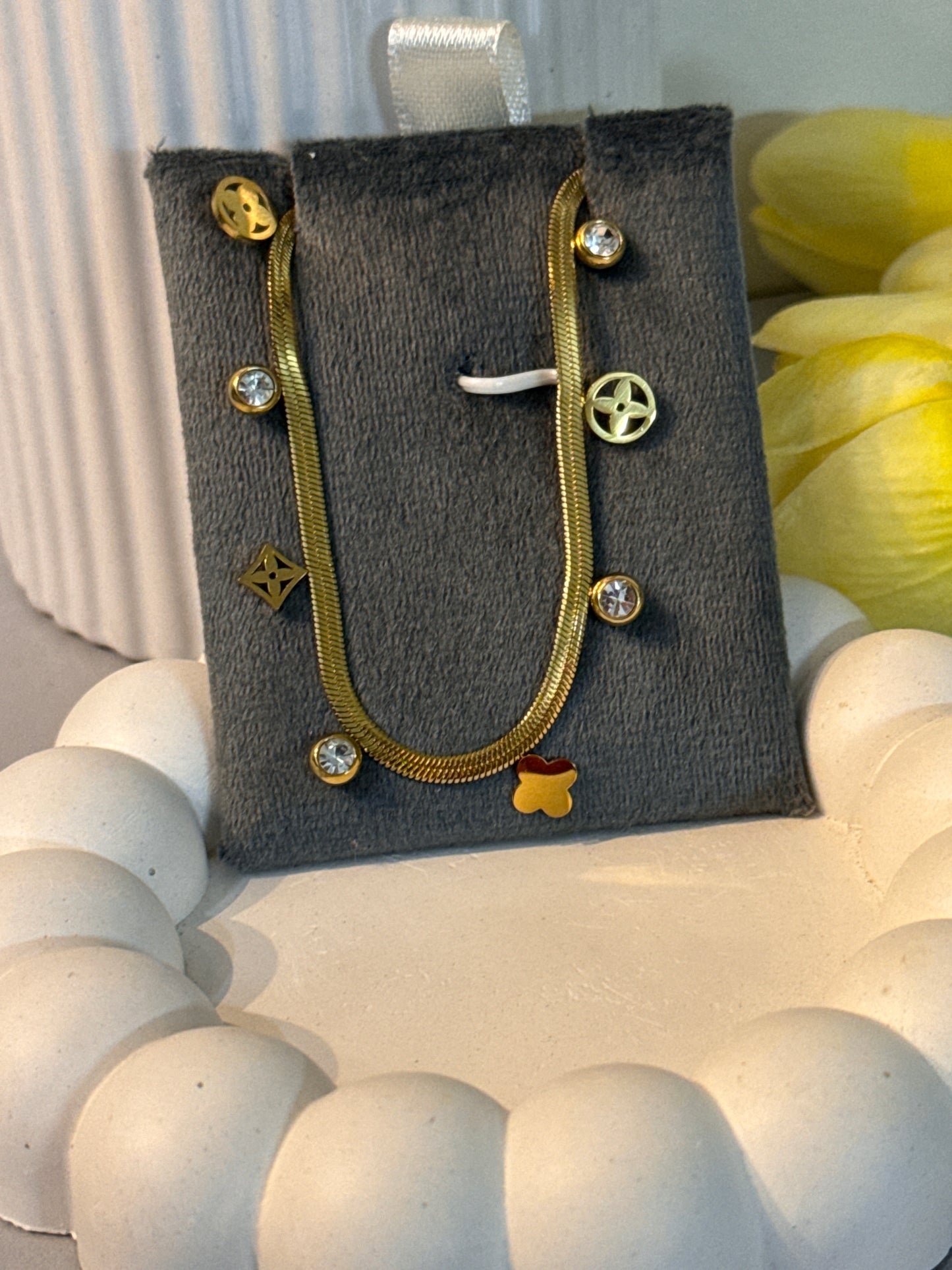 Gold jewelry on a gray card with decorative background
