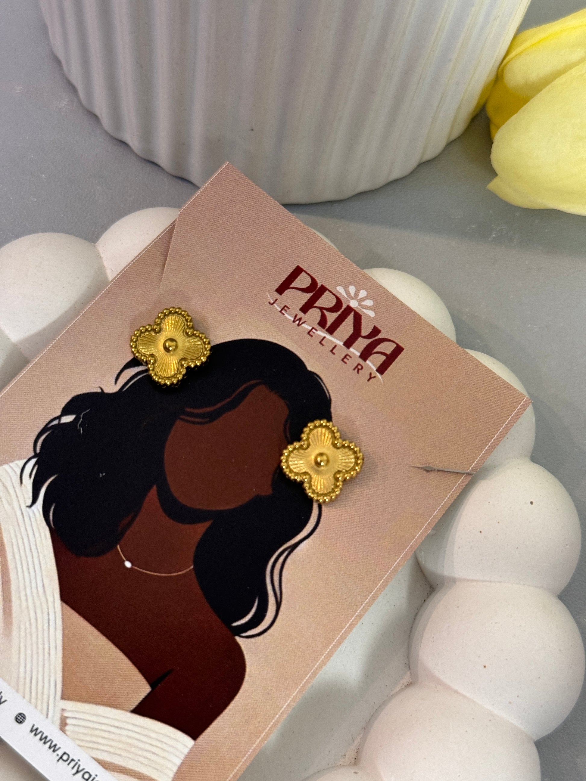 Earring on a card with 'Pryya' branding against a neutral background