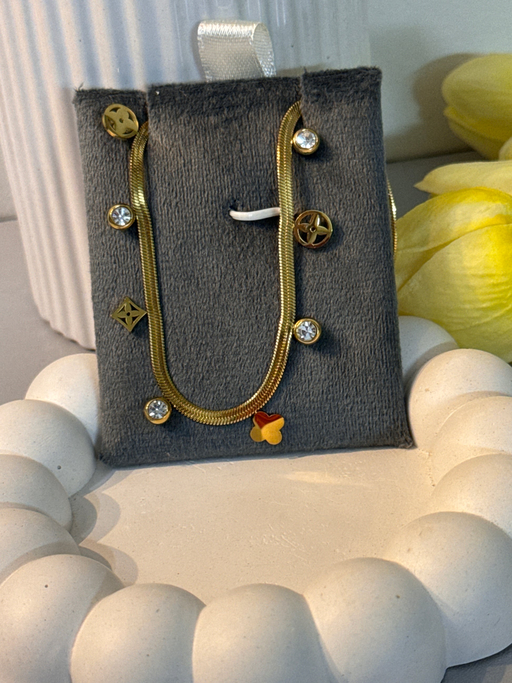 Gold earrings with gemstones on a gray earring card against a light background