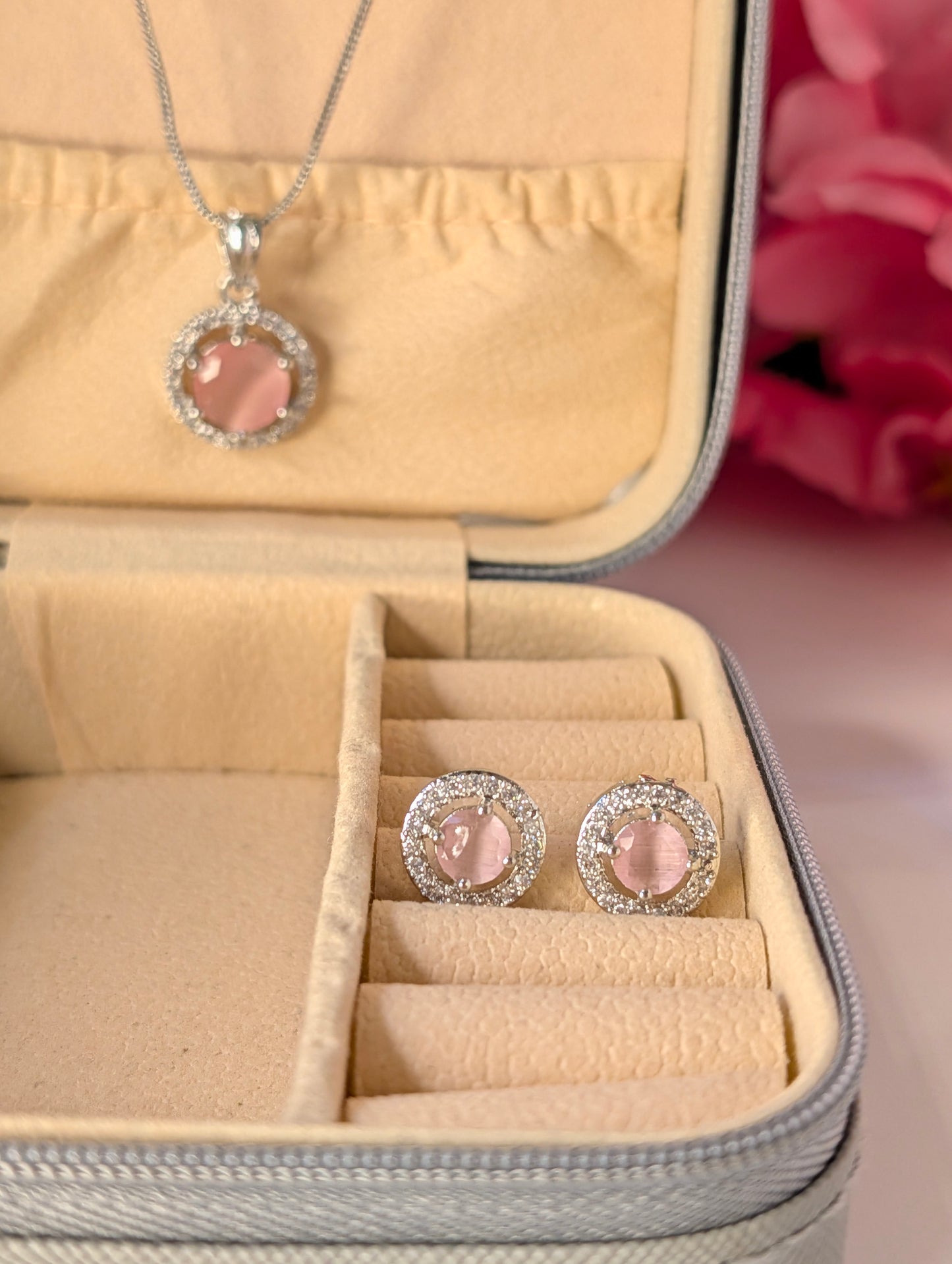 Jewelry set with pink heart-shaped stones in a beige jewelry box.