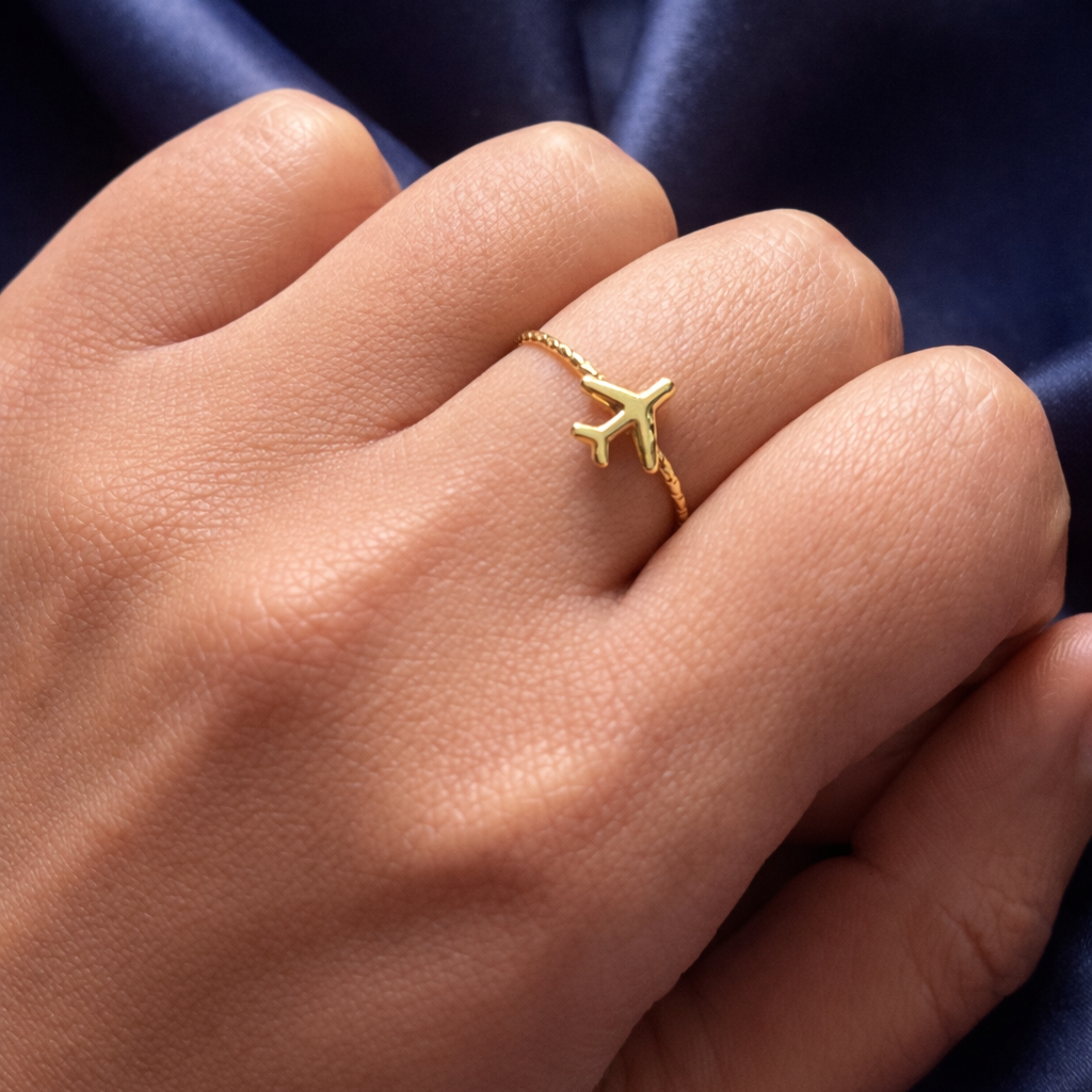 Gold ring on a person's finger against a blue fabric background
