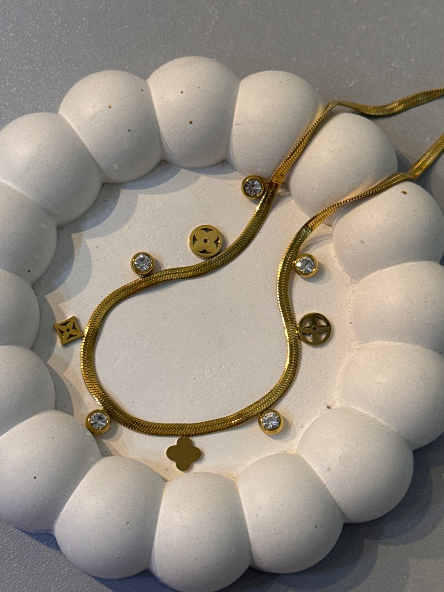 Gold necklace with decorative elements on a white background