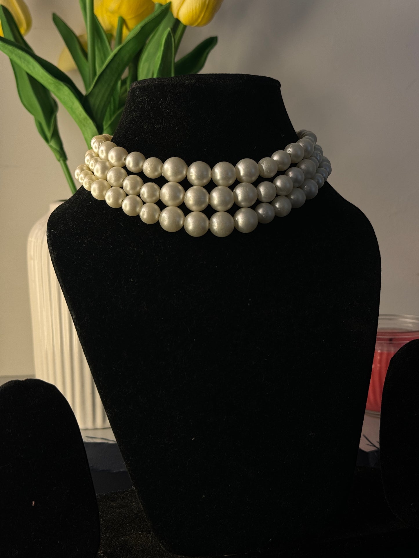 Pearl bracelet on a black stand with a blurred background