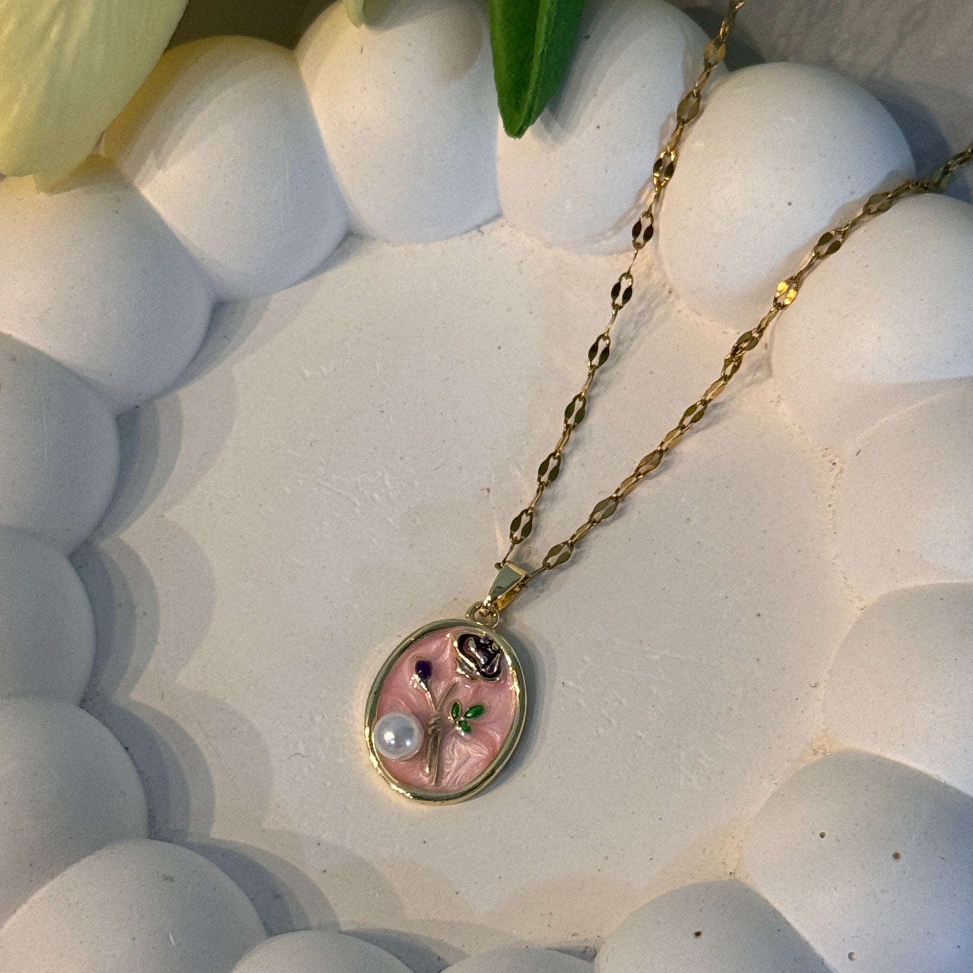 Necklace with a pink pendant on a white textured surface