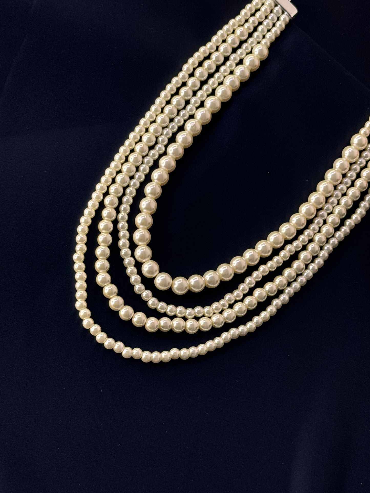 Multiple strands of pearls on a dark background