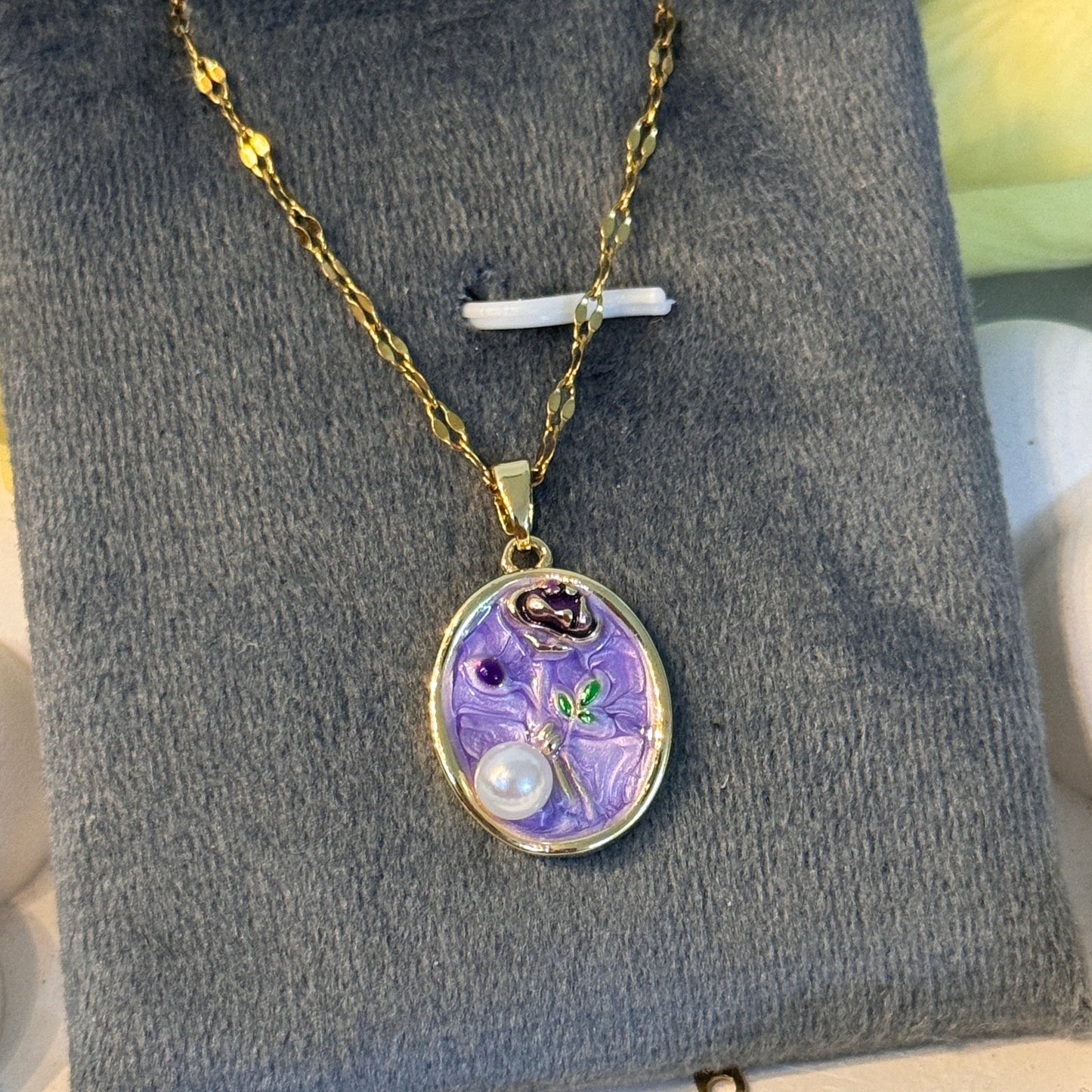 Necklace with a purple pendant on a gray surface