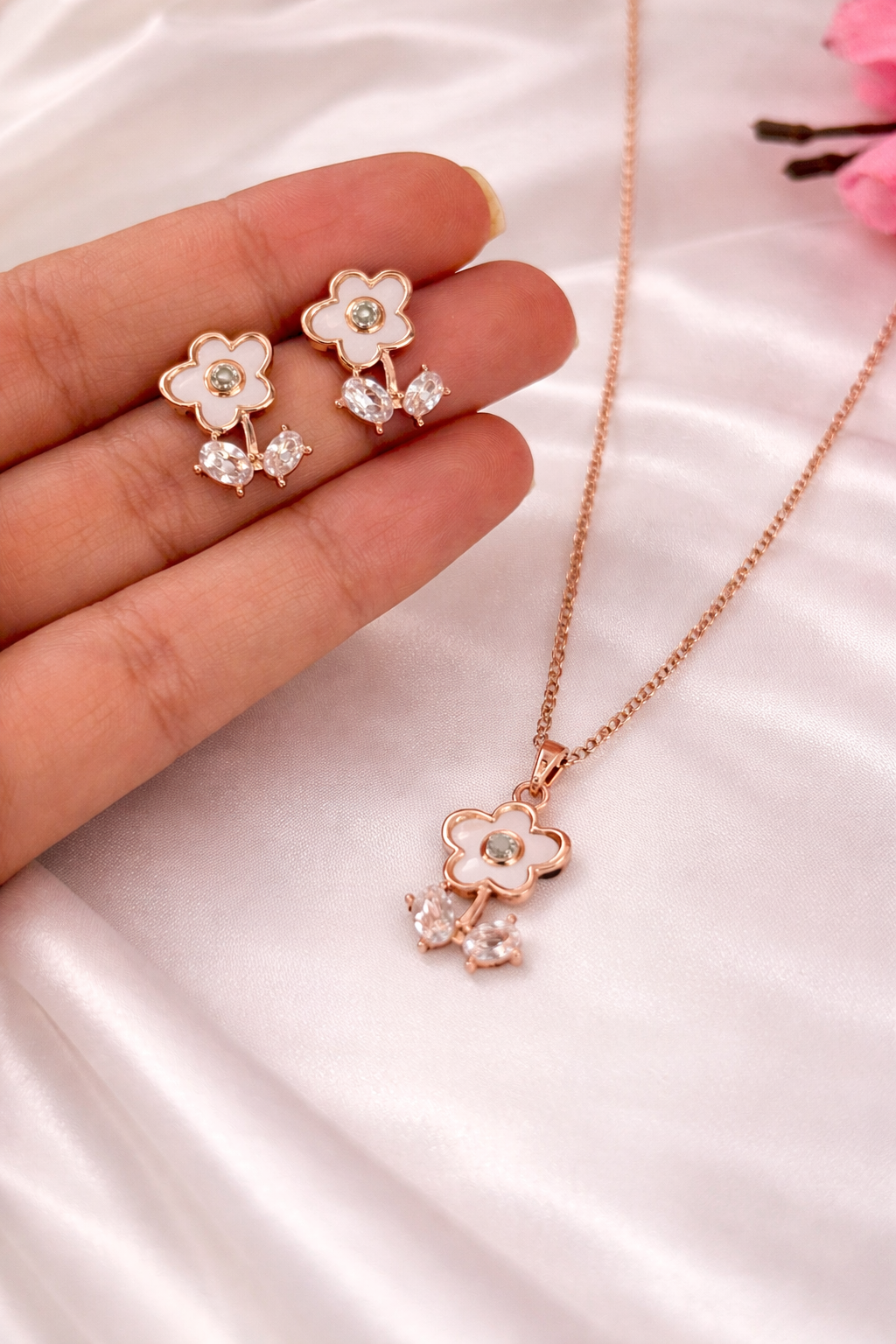 Rose gold floral jewelry set with earrings and necklace on a white background