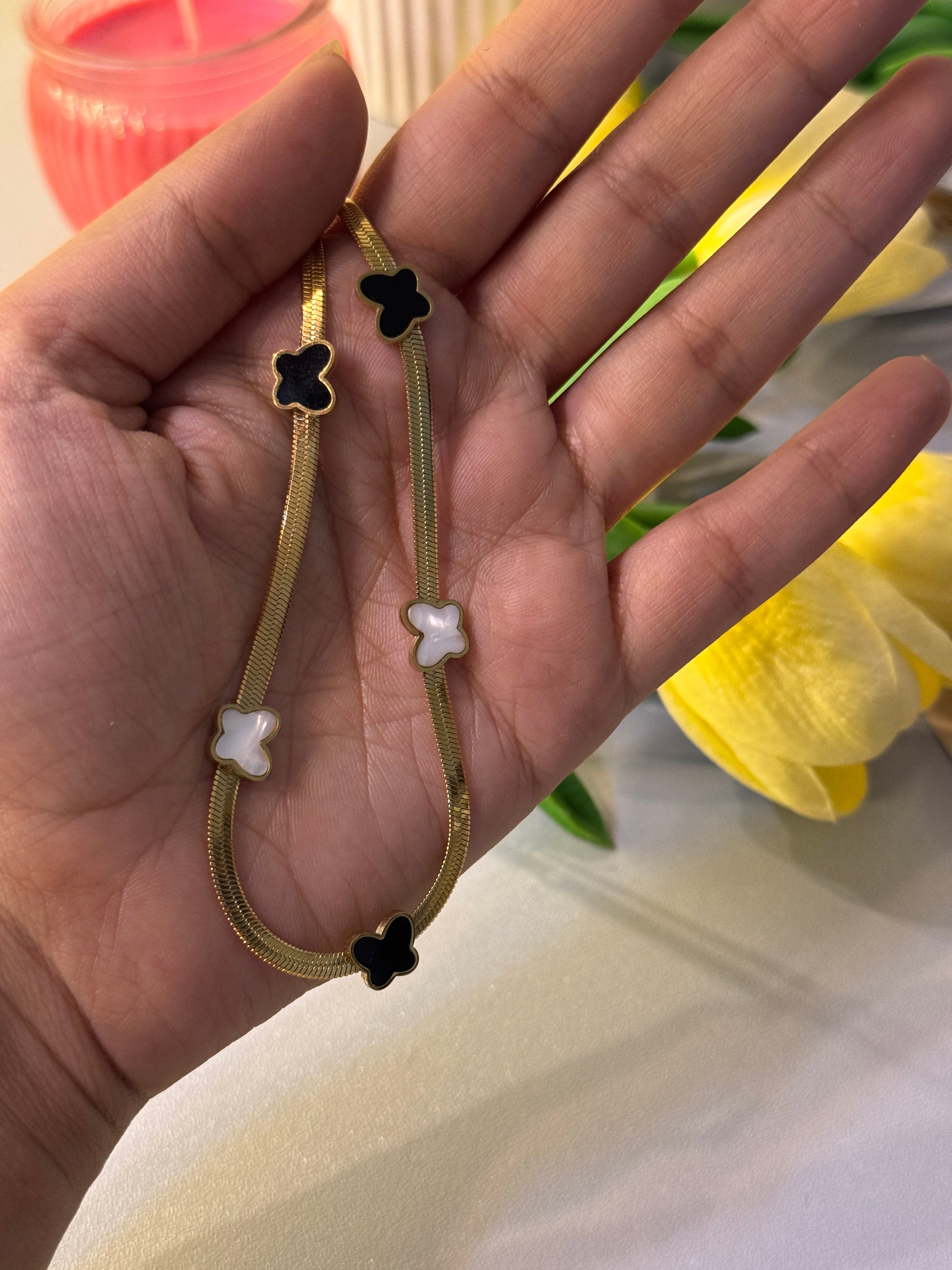 Gold bracelet with star-shaped charms on a hand, with a blurred background