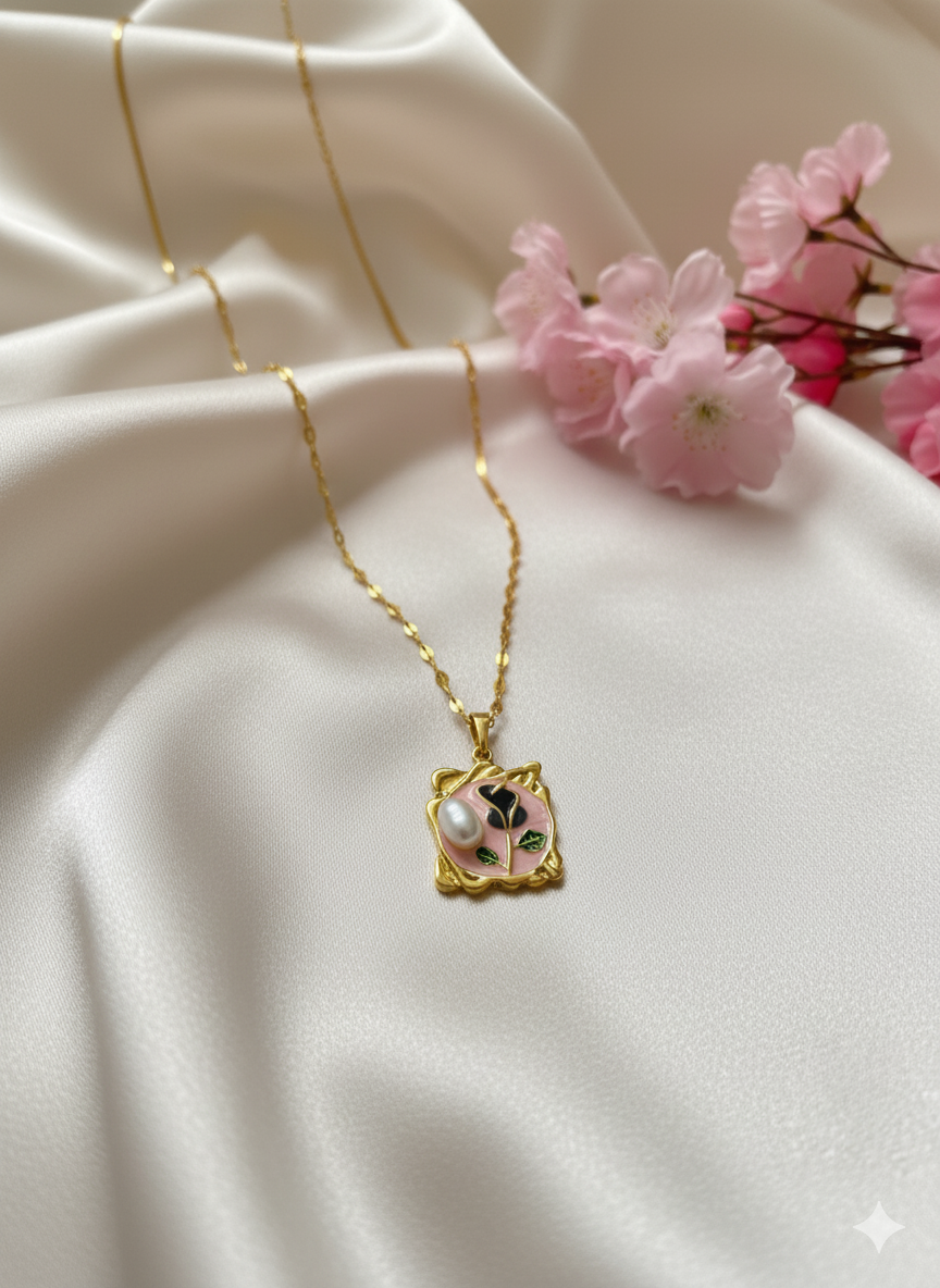 Gold necklace with a pink pendant on a white fabric background