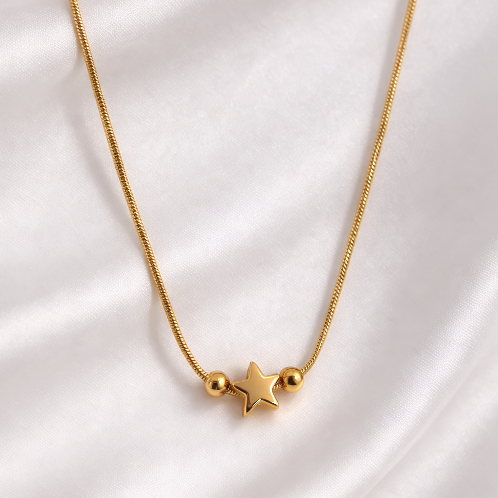 Gold necklace with star pendants on a white satin background