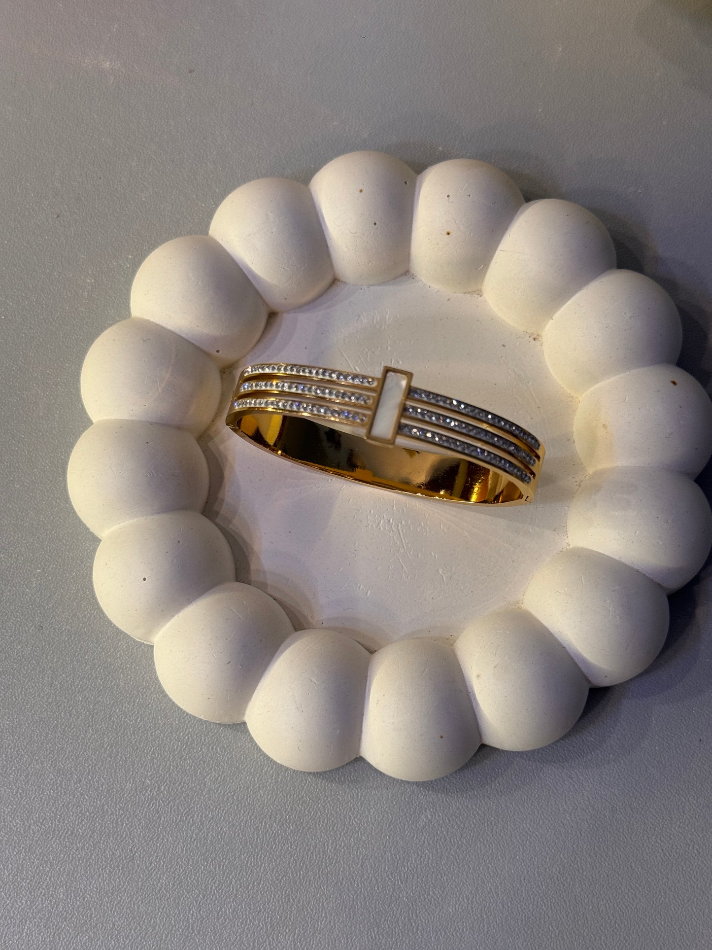 Gold ring with diamonds on a white stone base
