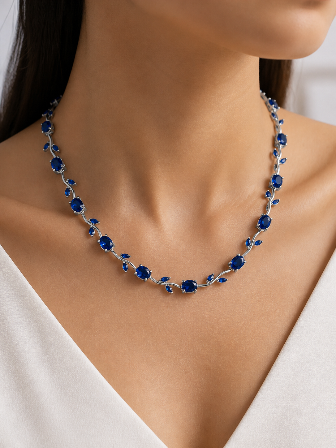 Necklace with blue stones worn by a model against a neutral background
