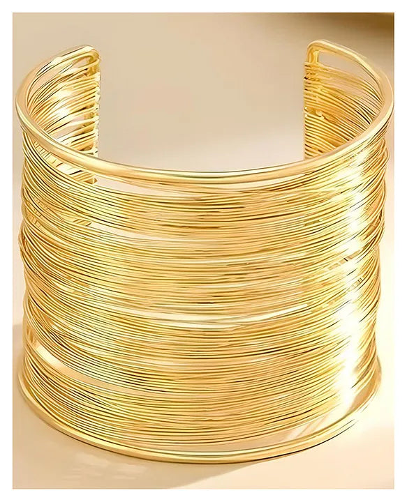 Gold wire cuff bracelet on a beige background