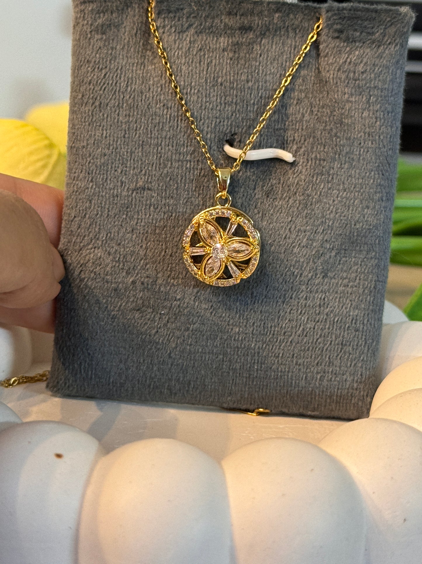 Gold necklace with a pendant on a gray surface