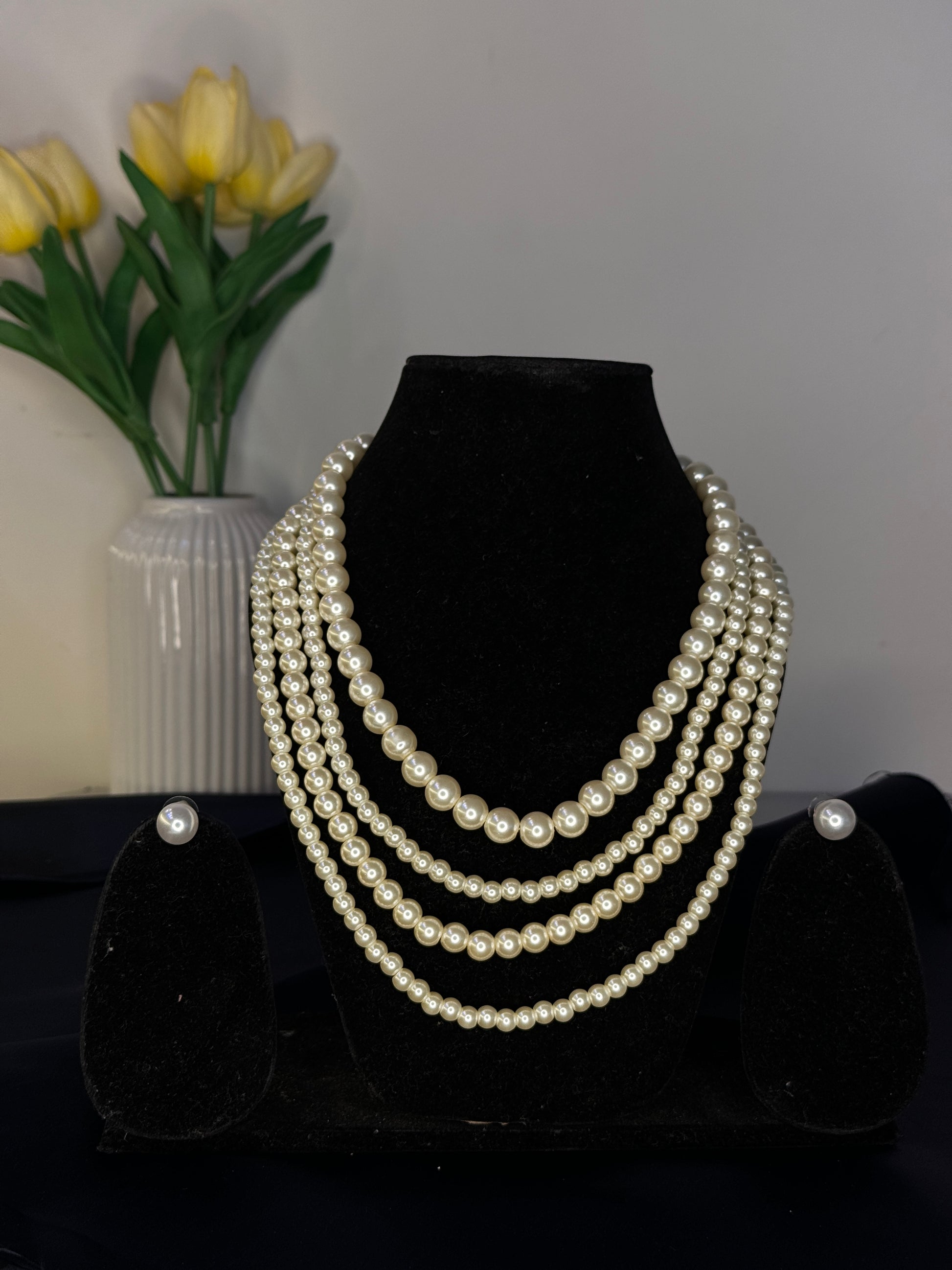 Set of pearl necklaces on a black stand with a blurred background