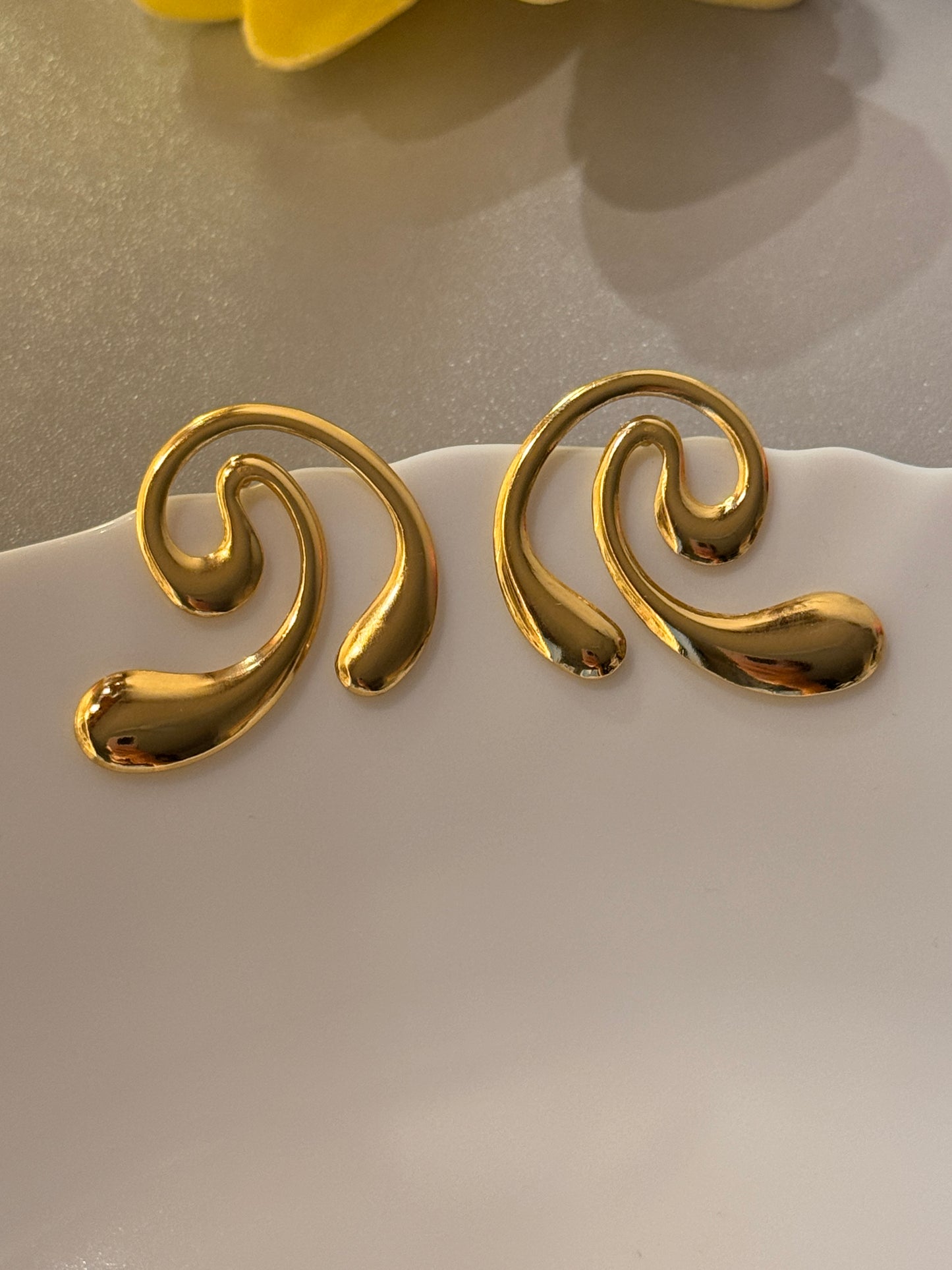 Gold spiral earrings on a white background