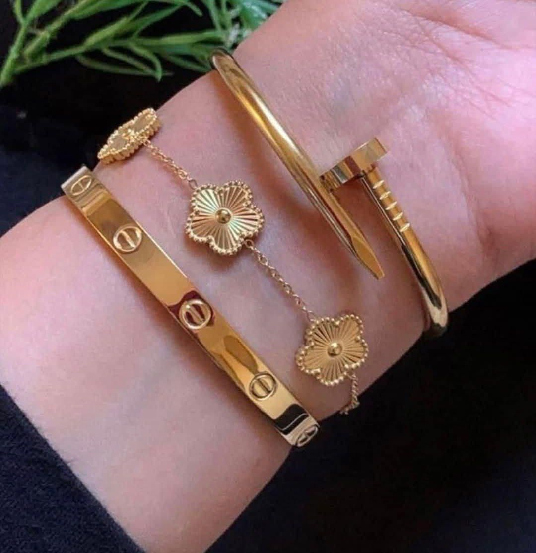 Gold bracelets on a wrist with a black background