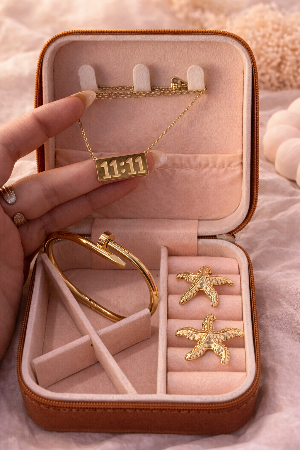 Gold jewelry set including necklace, bracelet, and earrings in a pink jewelry box.