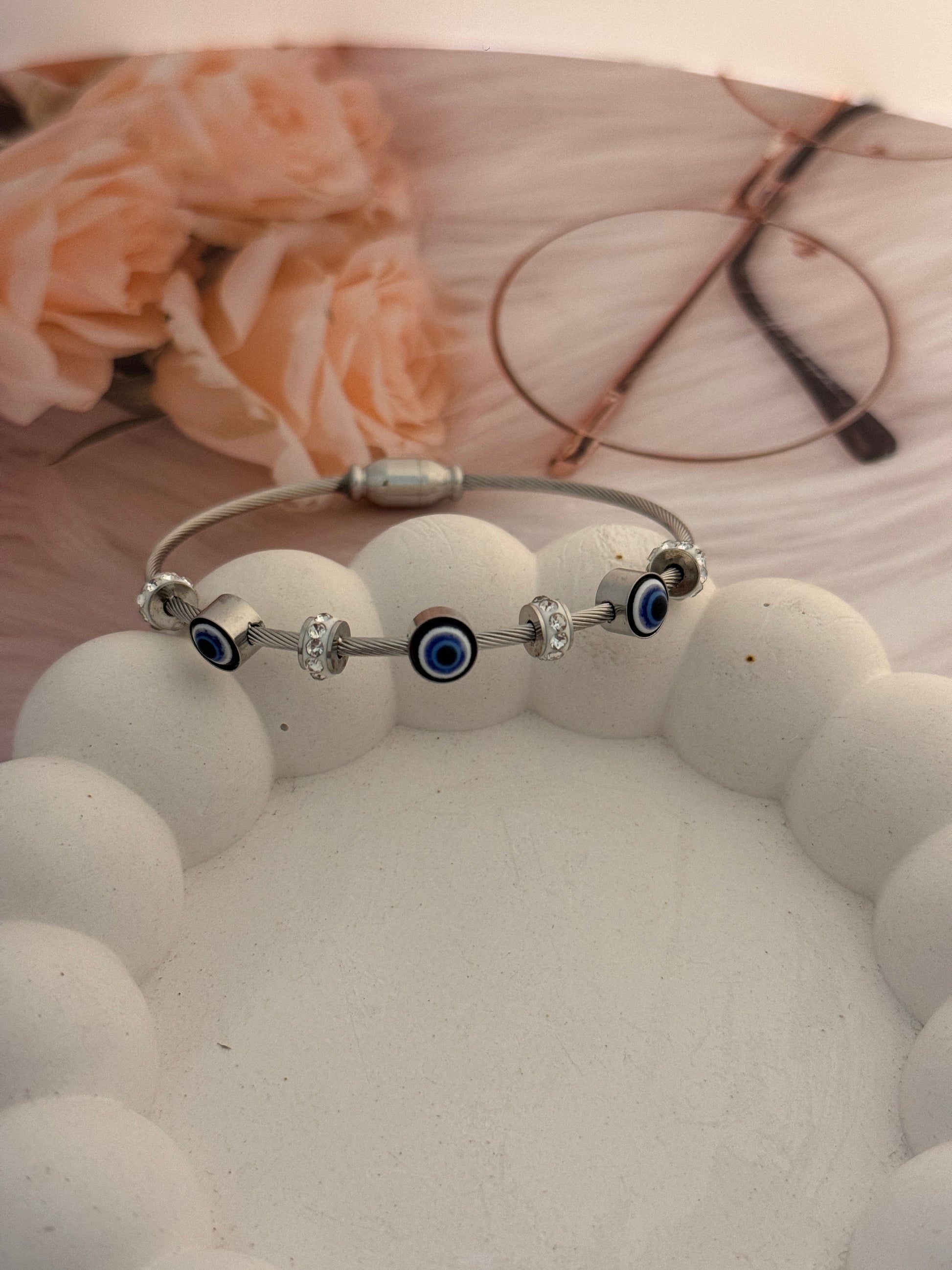 Silver belly button ring with blue gemstones on a white background with floral design