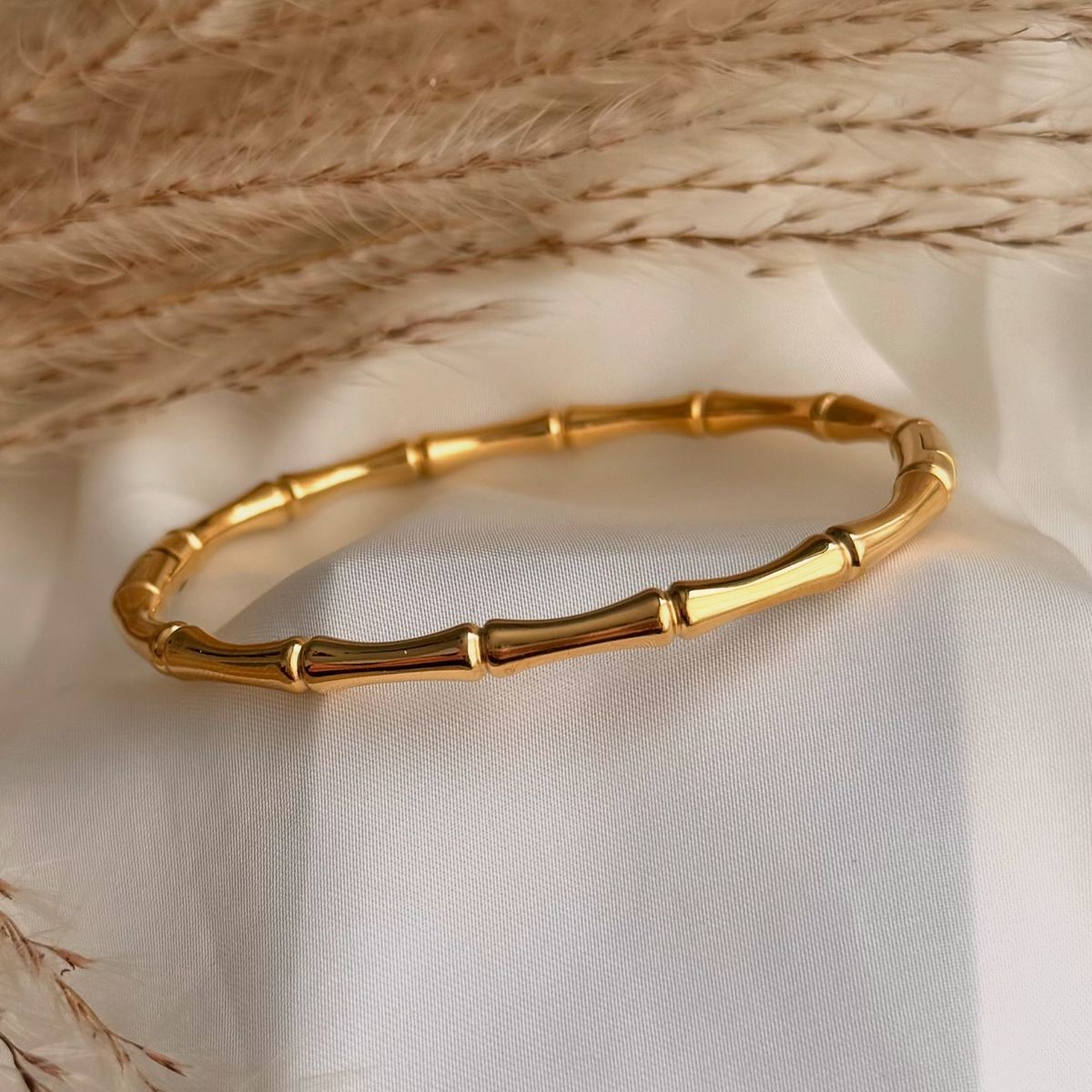 Gold bracelet on a textured beige fabric background