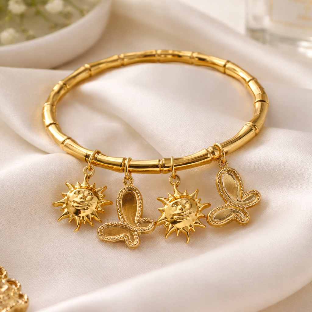 Gold bracelet with charms on a white fabric background