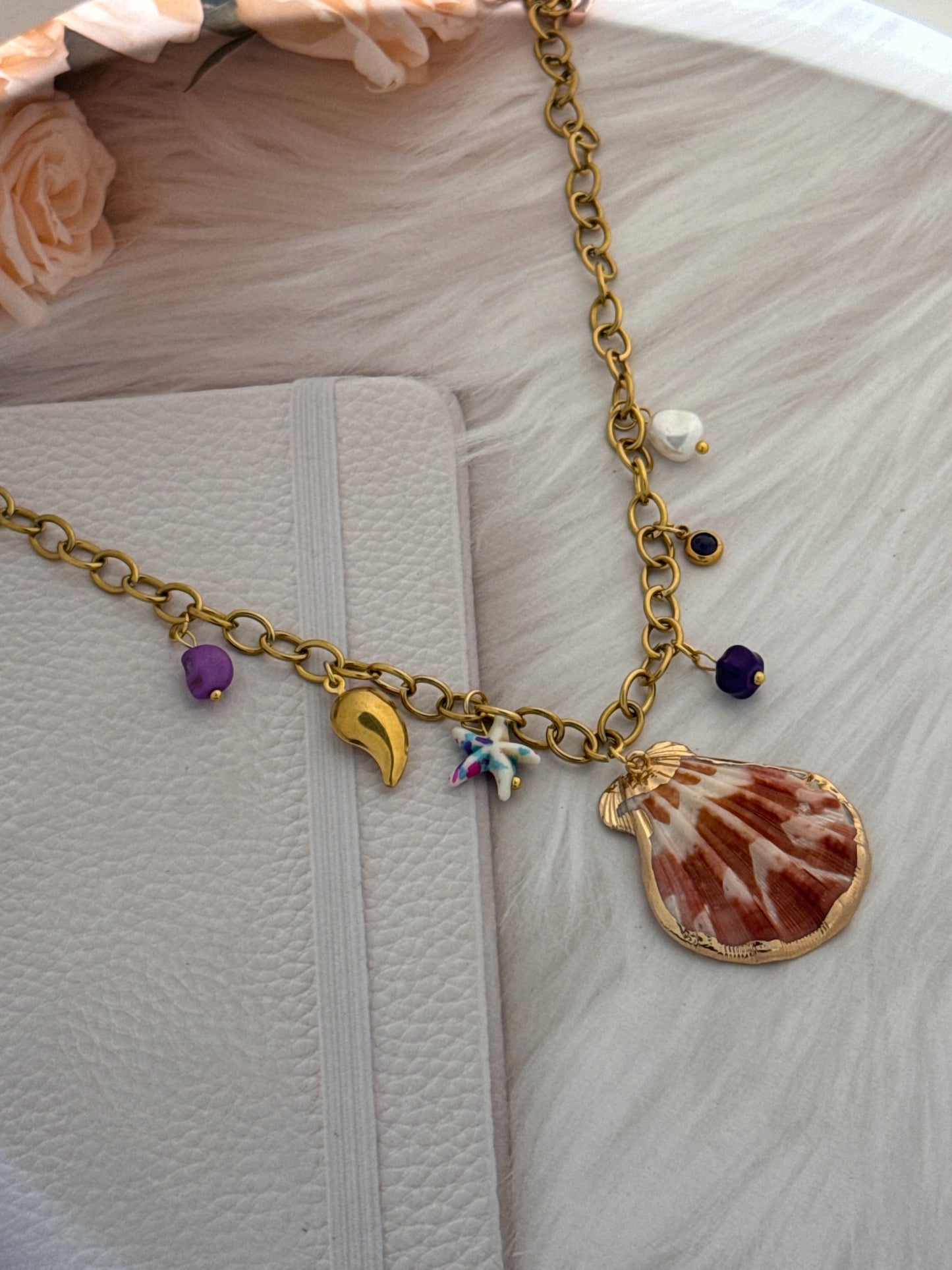 Necklace with various charms on a textured surface