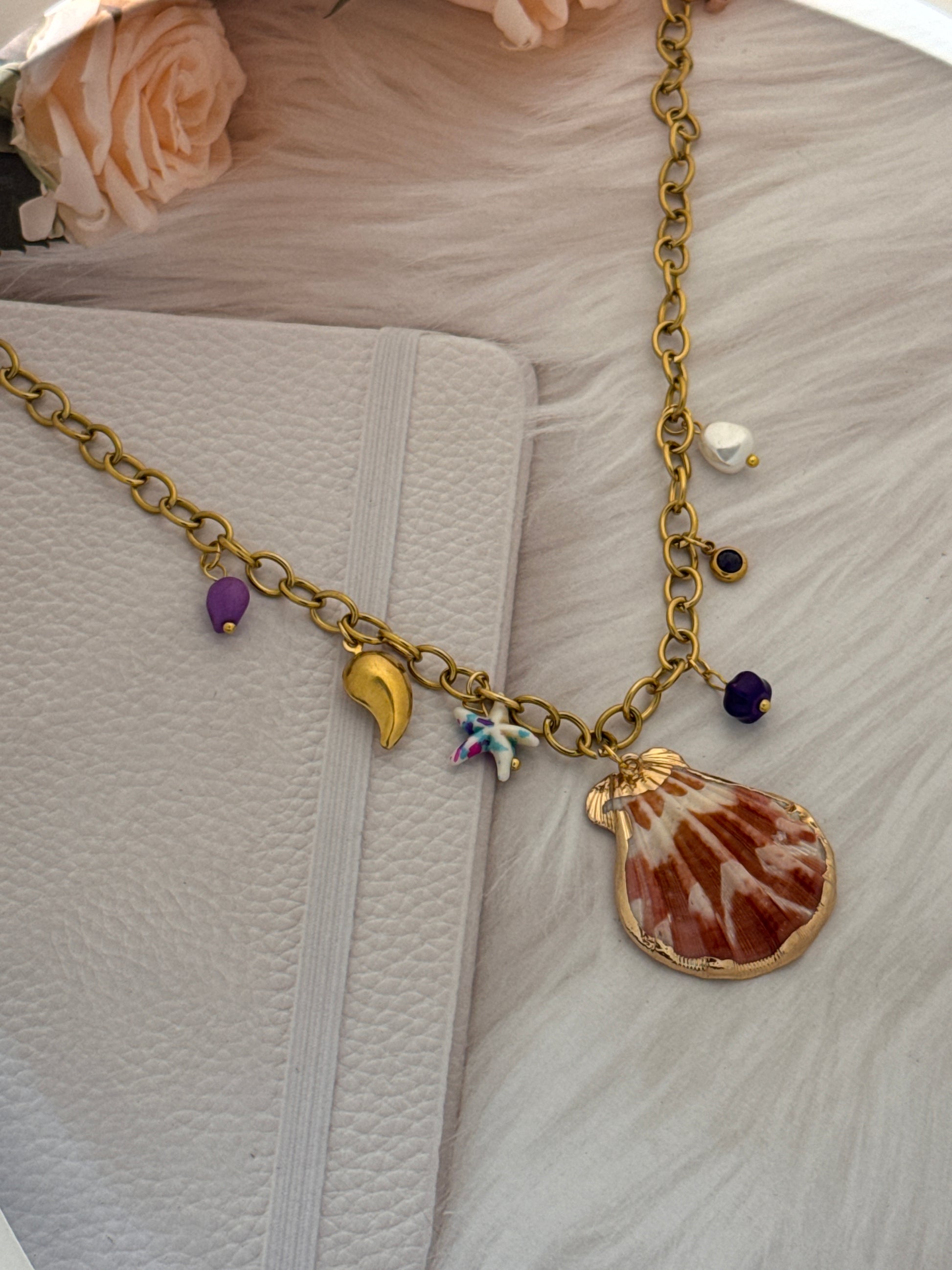 Gold chain with charms on a textured surface