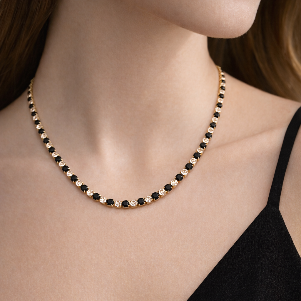 Necklace with black and gold beads on a person wearing a black top.