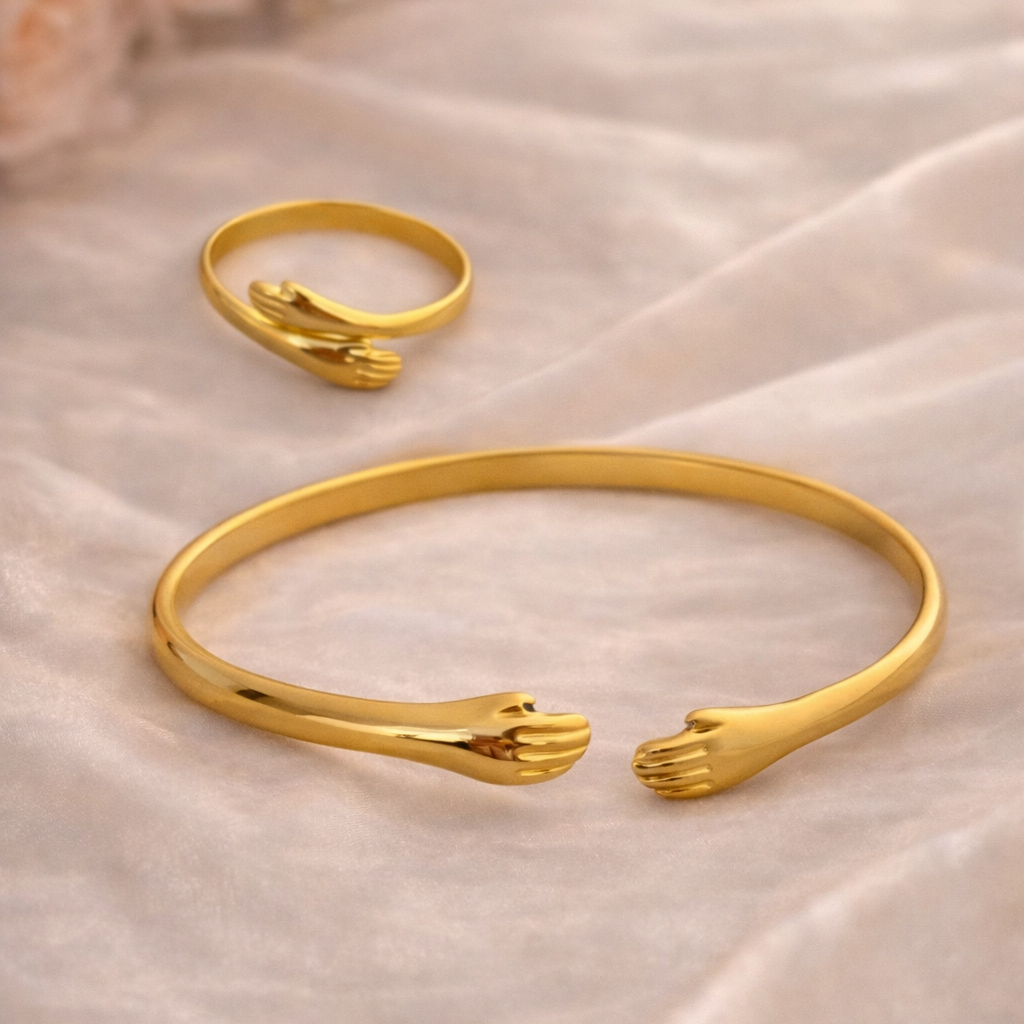 Gold bracelet and ring with hand design on a soft beige fabric background
