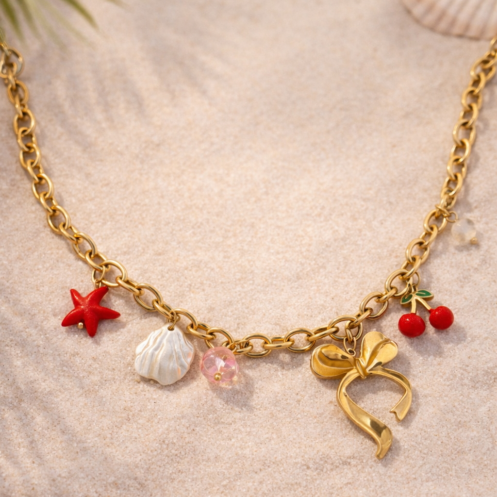 Gold necklace with various charms on a sandy background