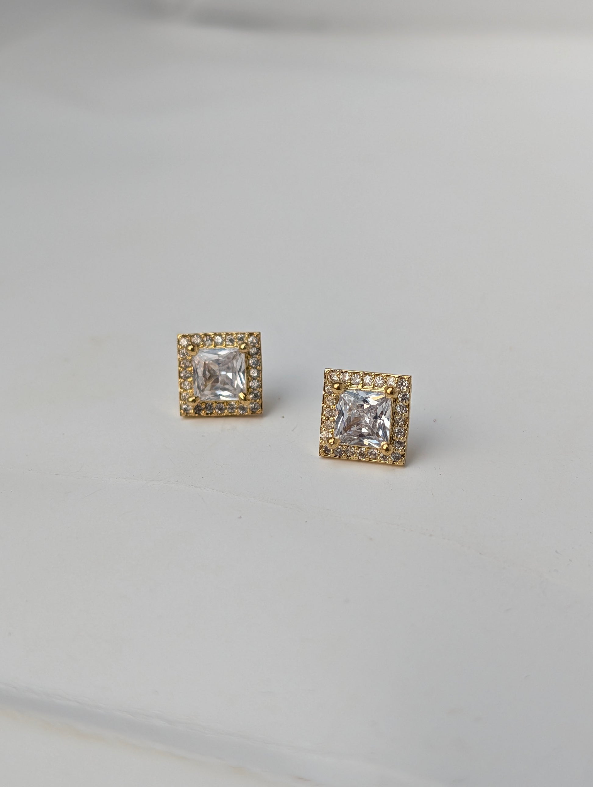 Pair of square-cut gemstone earrings with gold accents on a light gray background
