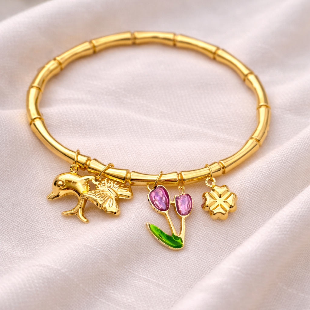 Gold bracelet with charms on a white fabric background