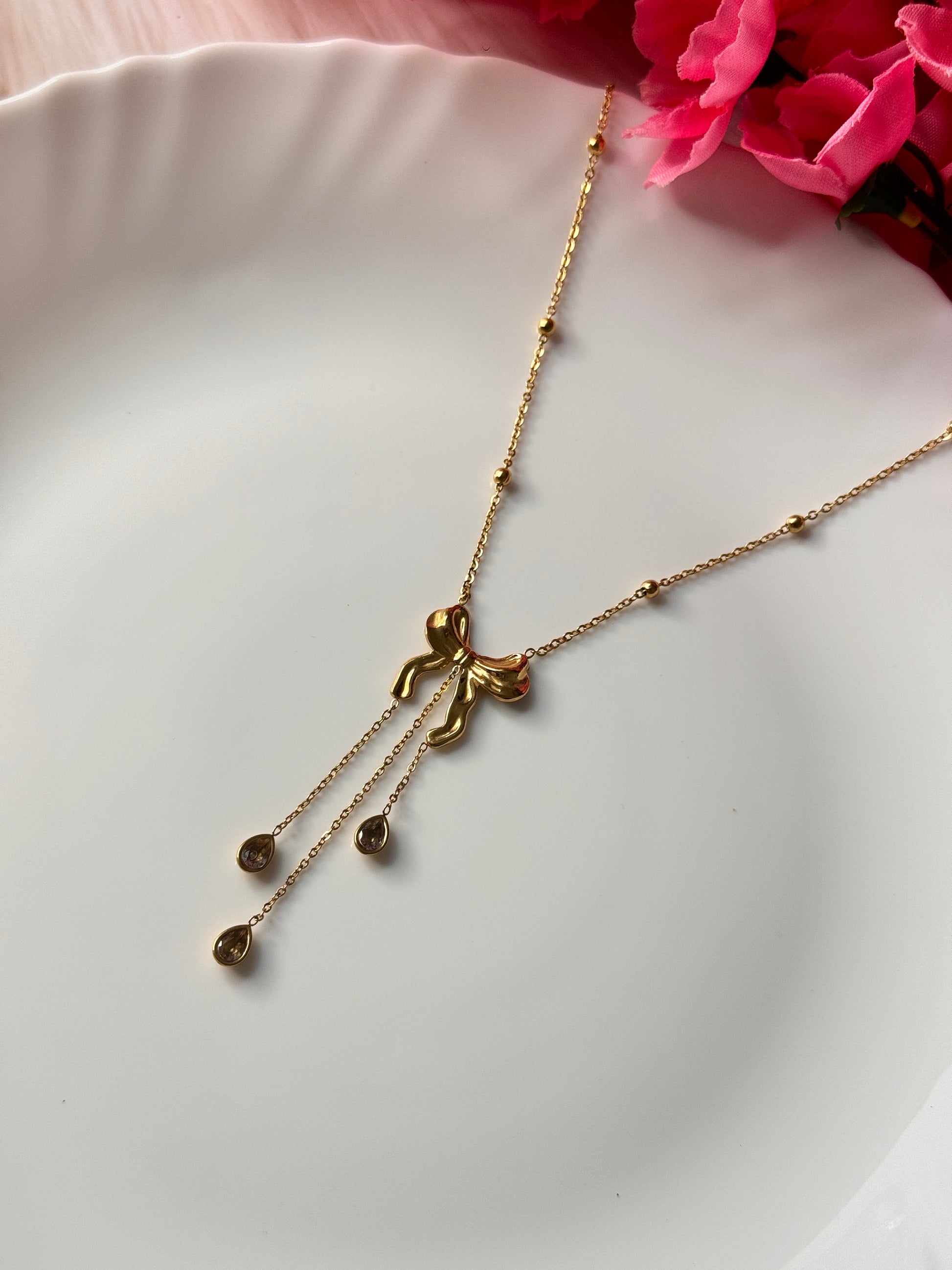 Gold necklace with a floral design on a white plate.