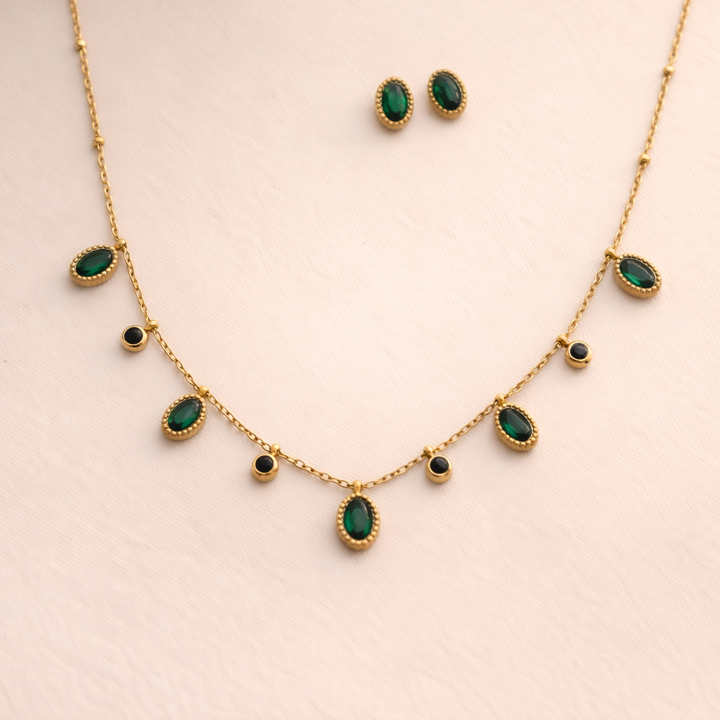 Gold necklace with green gemstones on a beige background