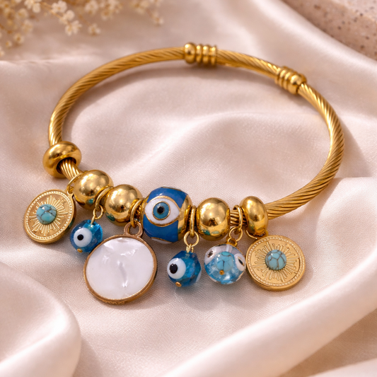 Gold bracelet with colorful beads on a beige fabric background