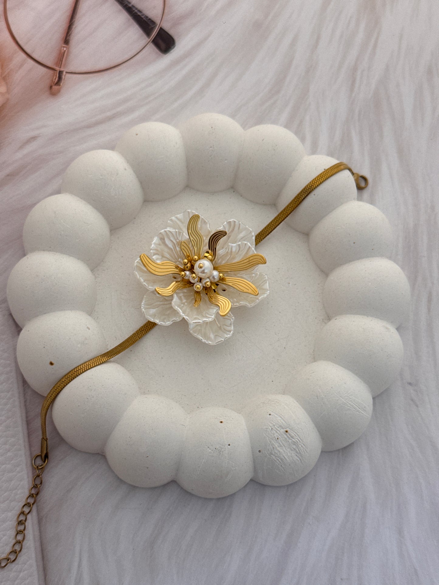 Necklace with a floral pendant on a textured surface