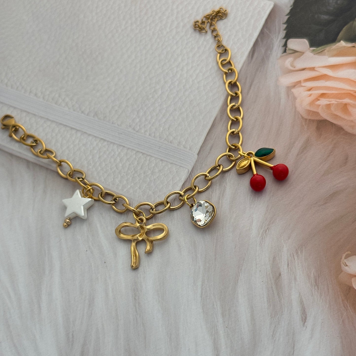 Gold bracelet with charms on a textured surface