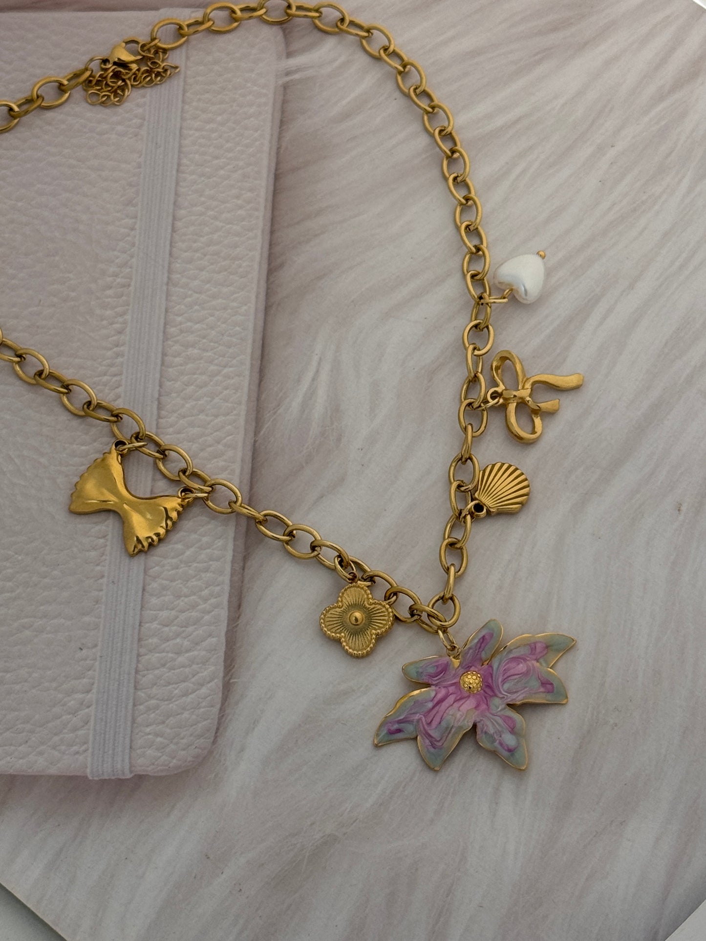 Gold bracelet with charms on a textured surface