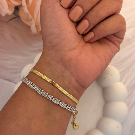 Close-up of a wrist with two bracelets against a soft background