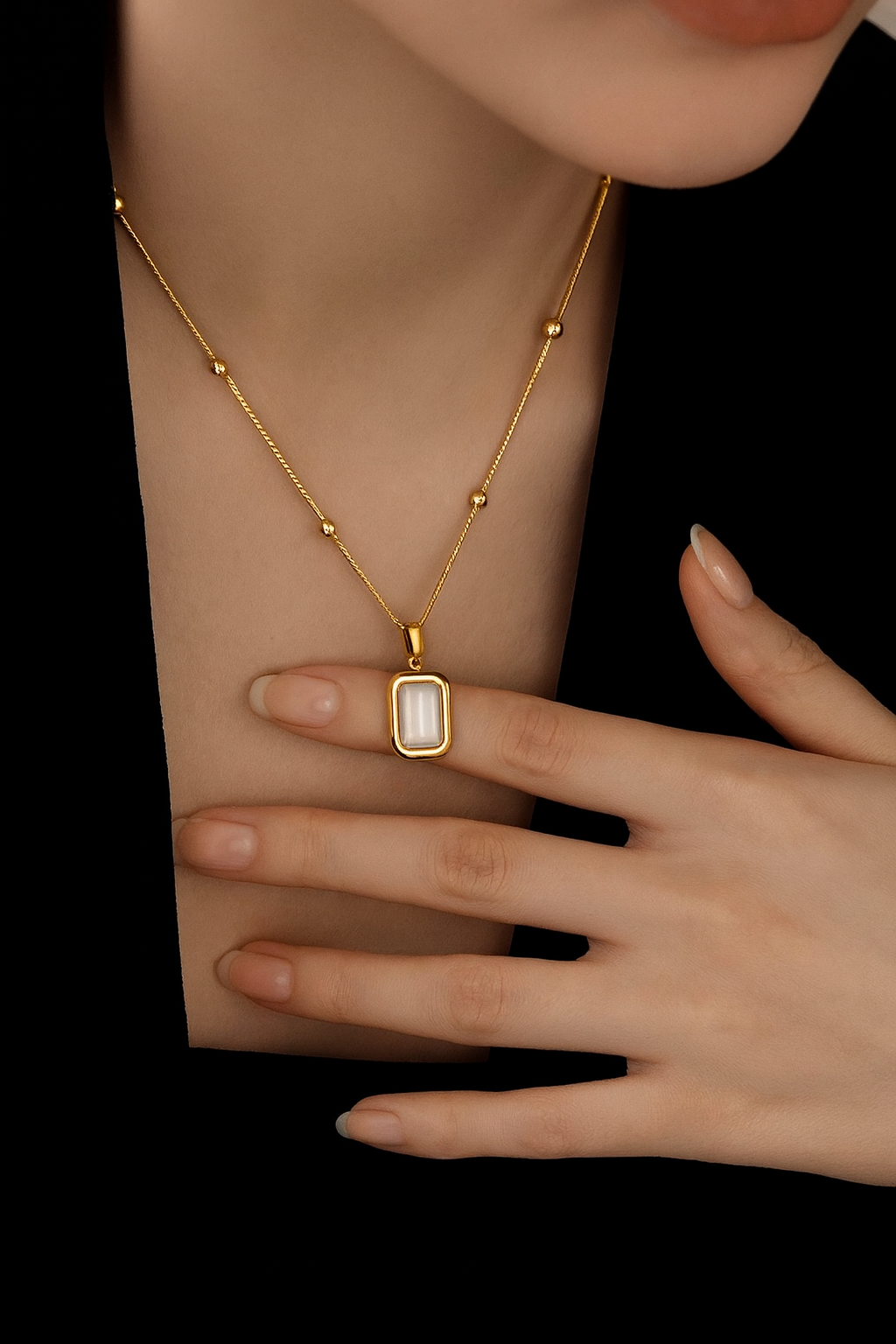 Gold necklace with a pendant on a black background