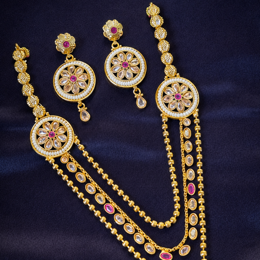 Gold jewelry set with earrings and necklace on a dark blue fabric background