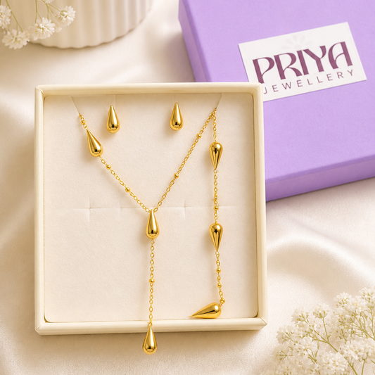 Gold necklace and earrings set in a box with a 'Priya Jewellery' branded box.