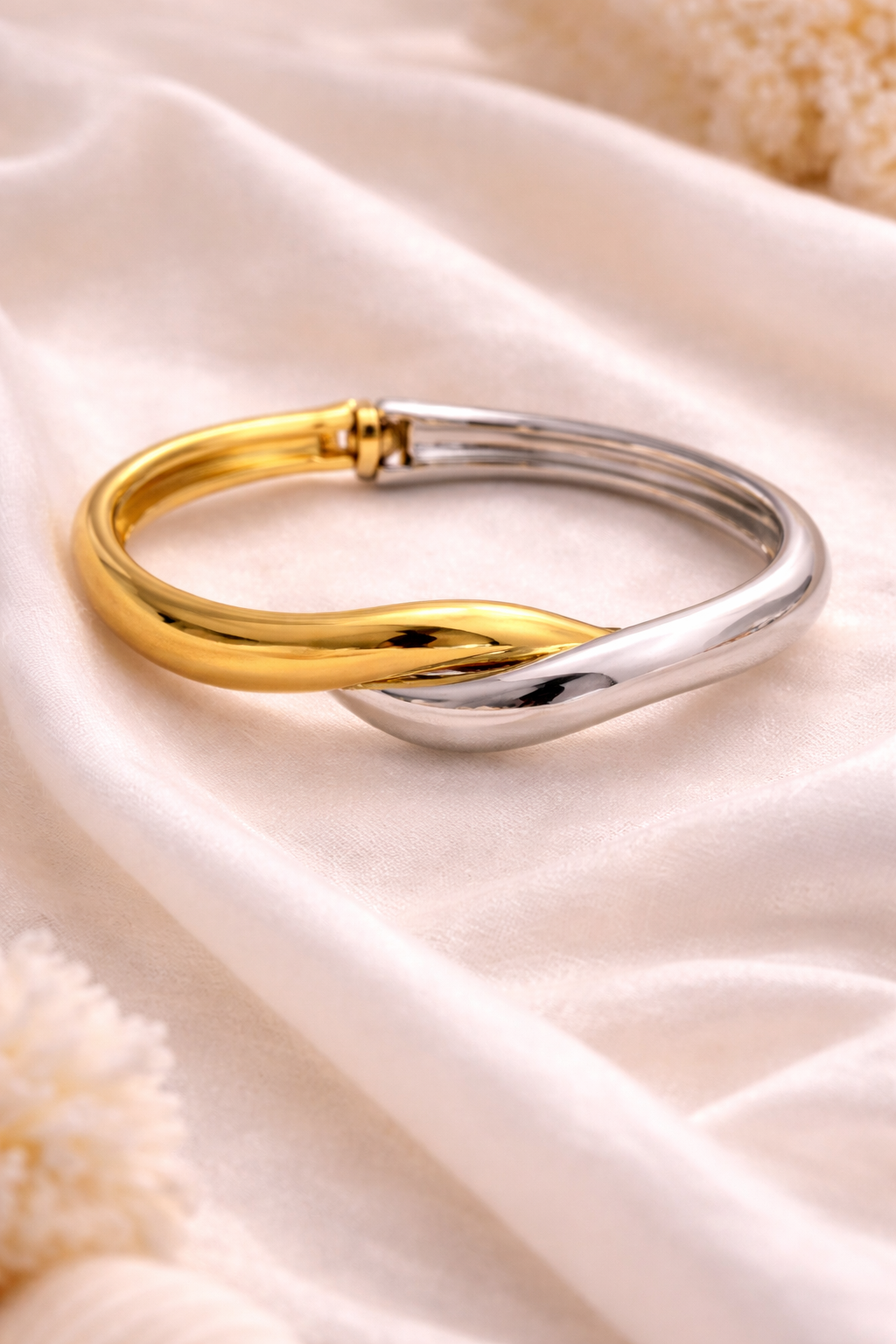 Gold and silver bracelet on a soft fabric background