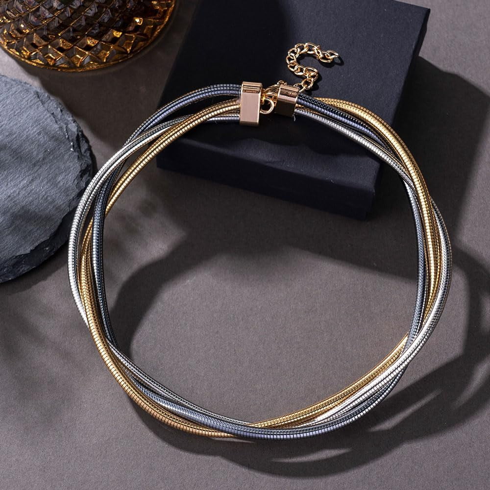 Gold and silver necklace on a dark surface