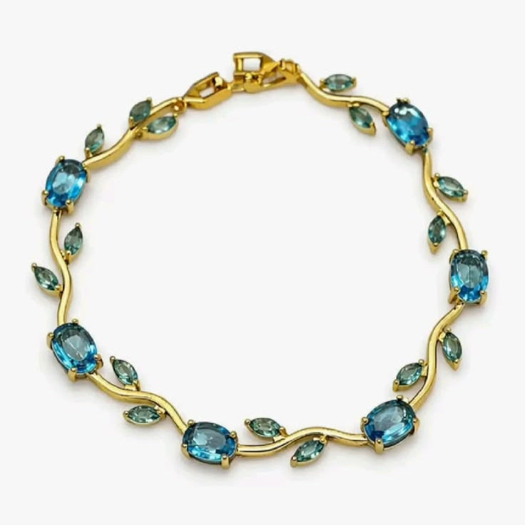 Gold bracelet with blue gemstones on a white background