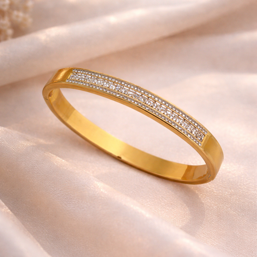 Gold bracelet with embedded diamonds on a soft fabric background